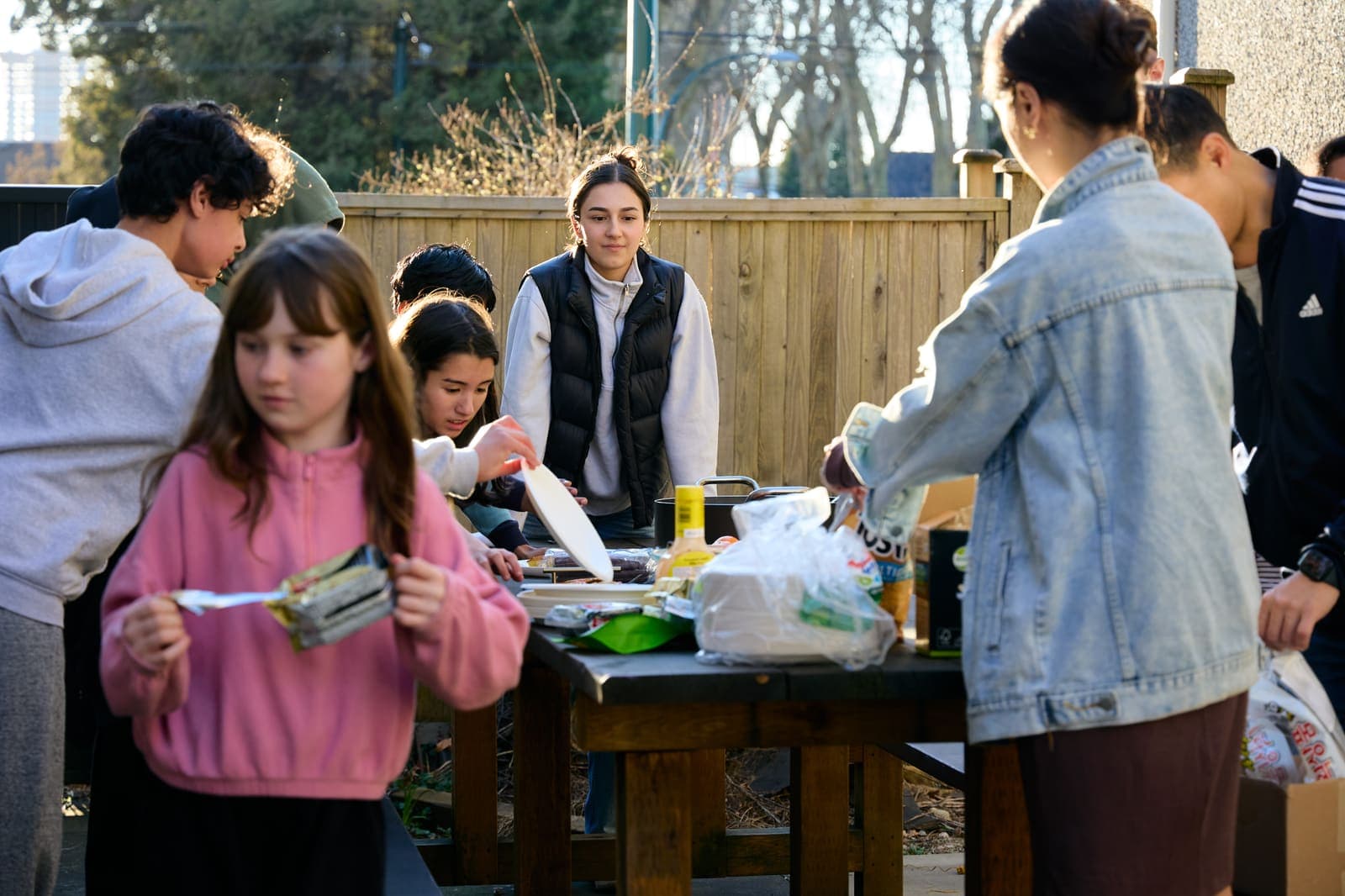 Junior youth sharing a meal together outdoors after a group activity.