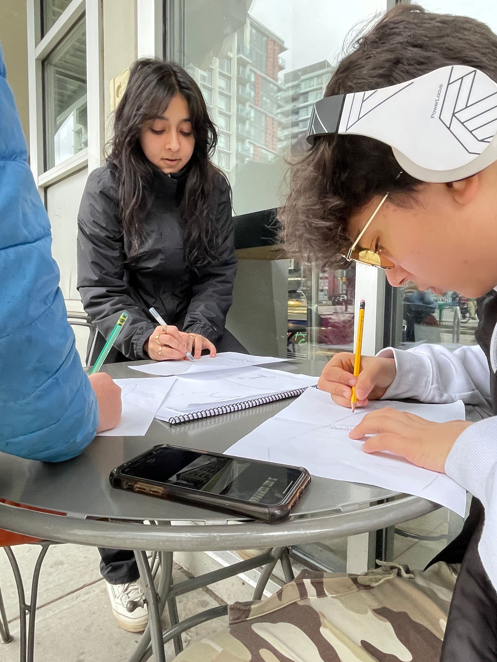 Junior youth working through the curriculum with pencils and notebooks around a table.